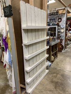 the shelves are made out of wood and have white boards on each shelf, along with other items