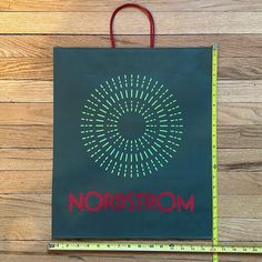 a green bag with the word nordstroom on it next to a ruler