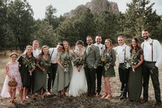 a group of people standing next to each other in front of trees and grass with flowers