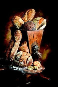 an oil painting of bread and pastries in a basket on top of a table