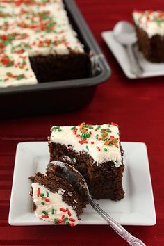 a piece of cake with white frosting and sprinkles is on a plate