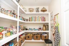 an organized pantry with white shelving and lots of food in baskets on the shelves