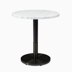 a white marble table with black metal base and round top, on a white background