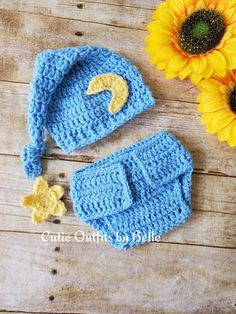 a crocheted hat, diaper and booties are sitting next to a sunflower