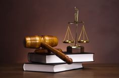 a judge's gaven and scale on top of two books with the scales of justice in front of them