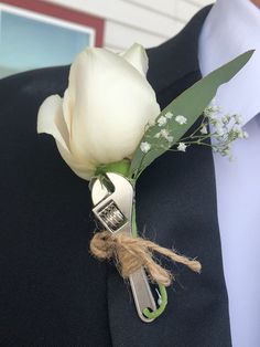 a boutonniere with a white rose attached to it