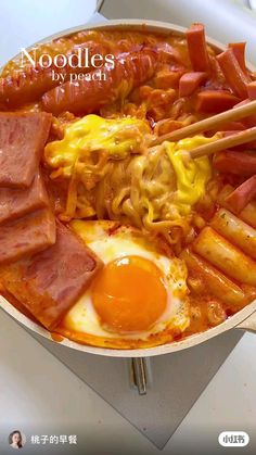 food in a pan with chopsticks and eggs