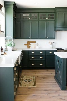 a kitchen with dark green cabinets and white counter tops is featured on the instagram page