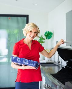 a woman in red shirt holding a blue tray