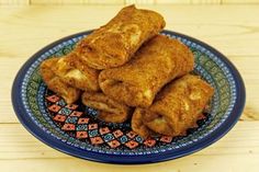 some fried food on a blue and red plate with a wooden table in the background