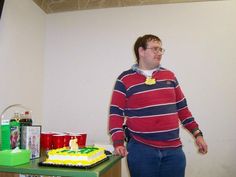 a man standing next to a table with a cake on it