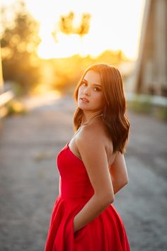 a woman in a red dress is posing for the camera with her hands on her hips