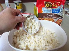 a person scooping diced food into a bowl