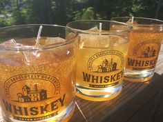 three glasses filled with liquid sitting on top of a wooden table next to each other