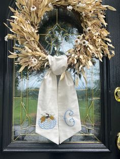 the front door is decorated with a wreath and two napkins that are tied to it