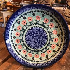 a blue and white plate sitting on top of a wooden table next to other plates