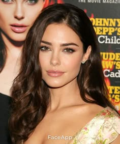 a close up of a person with long dark hair and wearing a dress on the red carpet