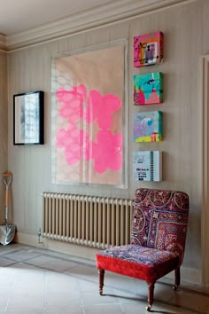 a living room filled with furniture and paintings on the wall above it's radiator