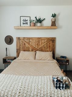 a bed with a wooden headboard and some plants on the top shelf above it