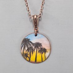 "Palm Tree Necklace Tropical Necklace Hawaiian Sunset Necklace Torch Enameled Necklace Torch Decaled Necklace Recycled Copper Necklace  I ship super fast. This unique handmade necklace is made from recycled sheet copper that has been torch enameled and decaled.  After I punch out the circle with a disc cutter I finish the edges so they are not sharp.  I then sprinkle a layer of powered enamel on the back surface and torch fire it until it is red hot.  When cooled, I enamel the front side.  After Retro Nickel Free Necklace For Gift, Retro Nickel-free Necklace For Gift, Retro Enamel Necklaces For Gift, Retro Nickel-free Necklaces For Gifts, Nickel-free Enamel Retro Jewelry, Tiki Necklace, Torch Fired Enamel Jewelry Copper, Sunset Necklace, Hand Painted Nature-inspired Pendant Necklace