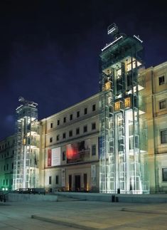 a large building lit up at night with lights on it's sides and windows