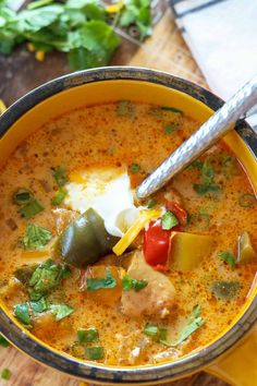 a yellow bowl filled with soup on top of a wooden table