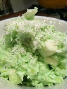 a white bowl filled with green food on top of a table