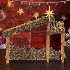 a nativity scene with a star on top of a house made out of logs