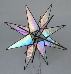 a multicolored glass star ornament hanging on a wall