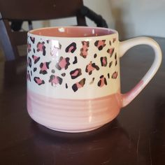 a pink and white leopard print coffee mug on a table