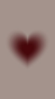 a red heart shaped object on a gray background with the light reflecting off it's side