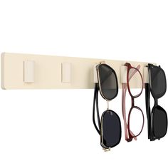 three pairs of sunglasses hanging on a wall with eyeglasses attached to the hooks