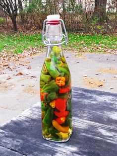 a glass bottle filled with lots of vegetables