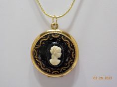 Vintage cameo hinged locket pendant. 1" diameter. Plastic photo covers inside. Lid is black enamel with gold tone design surrounding the cameo. 18" chain with lobster claw fastener.  Pendant closes perfectly. Excellent condition. Unsigned. Cameo Medallion Locket Necklace, Antique Gold Cameo Medallion Locket Necklace, Black Round Cameo Jewelry, Black Cameo Medallion Jewelry, Black Cameo Medallion Necklace, Beautiful Pearl Necklace, Vintage Cameo, Faux Pearl Necklace, Black Enamel