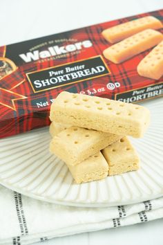 three crackers on a plate next to a packet of shortbread