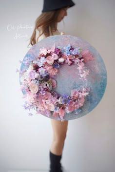 a woman is holding a blue plate with pink flowers on it and the bottom half of her body