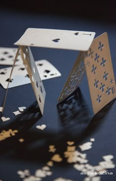 playing cards are cut out and placed on a table with scattered confetti around them