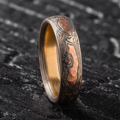 a wedding band that has been made with wood and gold inlays on it