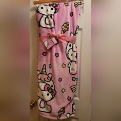 a pink hello kitty blanket hanging on a door