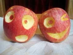 two apples with faces carved into them