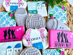 decorated cookies in the shape of people with names and pictures on them are sitting next to a basket full of flowers