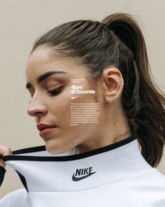 a woman with her hair pulled back in a ponytail and the words nike on it