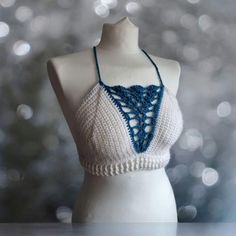 This one of a kind bralette will make you stand out wherever you go!  Featuring:  Deep V blue shell detailing! White ribbing around the waist! A criss cross back! Made in both white and turquoise 100% acrylic yarn.  Perfect for festivals with high waisted denim shorts or harem pants!  Bralette pictured is made to fit size medium and is ready to dispatch!  Full Sizing details:  Small - A-B cup  Medium - B-C cup Large - D cup  XL - DD cup Sizes vary depending on the coverage you want so if you are White Halter Neck Crop Top With Built-in Bra, White Crop Top With Built-in Bra, White Triangle Crop Top With Built-in Bra, White Halter Crop Top With Built-in Bra, Festival Bra Friendly Cropped Top, Handmade White Halter Top For Vacation, White Crop Top With Built-in Bra And Triangle Shape, White Crop Halter Top With Built-in Bra, Bohemian Crop Top With Built-in Bra For Festivals