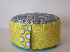 a yellow and blue poufle sitting on top of a table