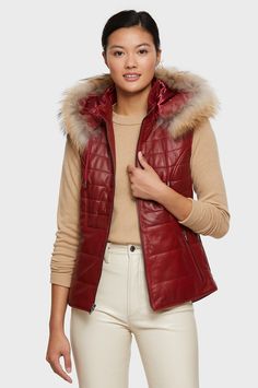 Sport casual luxury from fall to spring in the Maria vest, a quilted lambskin leather vest insulated with poly fill for lightweight warmth. On extra-cold days, attach the removable hood that's trimmed with beautiful natural Asiatic racoon fur and pull the drawstring to cinch in the heat. Detach the hood when the sun comes out to play and you'll be the picture of sporty chic in the sleek quilted leather style. Two outer zip pockets keep keys and gloves handy. Luxury Leather Women's Vest, Luxury Leather Winter Vest, Leather Sleeveless Winter Vest, Fitted Leather Outerwear With Double-lined Hood, Leather Coat With Fur, Moto Jacket Style, Sleeveless Leather Vest With Button Closure, Trench Coat Style, Lambskin Leather Jacket