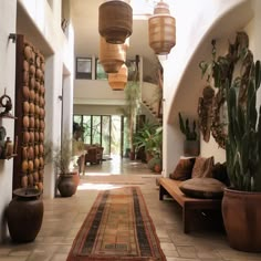 a hallway with potted plants and hanging lights