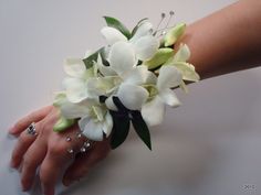 a woman's hand holding a bouquet of white flowers