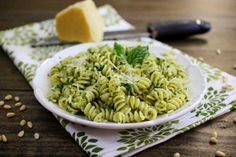 a white plate filled with pasta and parmesan cheese on top of a table