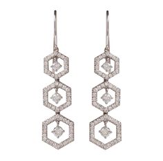 3 Hexagon shaped snowflake like drops set in 18 KT. white gold.  Each delicately set diamond hexagon has a diamond at its center that shimmers with movement suspended from a tiny jump ring.   Ever so delicate and yet very striking.  These earrings make a statement!.  Like shimmering snow.  1.25 inch drop from top of earring to the bottom, 10mm wide.  Simple shepherds hook 18KT wire backs.   Approx. 1.86 Cts  total diamond weight. G-H Color  VS-SI Clarity. Silver Octagon Earrings With Diamond Accents, White Gold Octagon Diamond Earrings, Octagon Diamond Cut Earrings, White Gold Diamond Octagon Earrings, Fine Jewelry Earrings With Diamond Accents In Octagon Shape, Octagonal Earrings With Diamond Accents, Diamond White Octagon Earrings In Fine Jewelry Style, Silver Diamond Octagon Earrings, Hexagon Diamond Jewelry With Brilliant Cut