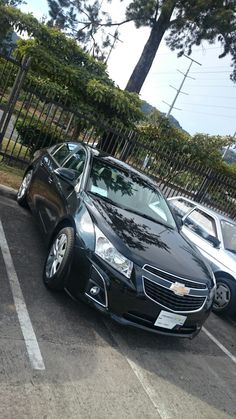 two cars parked in a parking lot next to each other